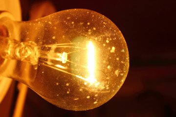 Dusty glowing light bulb. Close-up. Background. Texture.