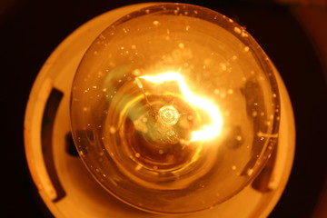 Dusty glowing light bulb. Close-up. Background. Texture.