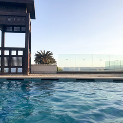 Rescue booth, tower, rescue post on the edge of the water of a luxurious infinity pool merging with...