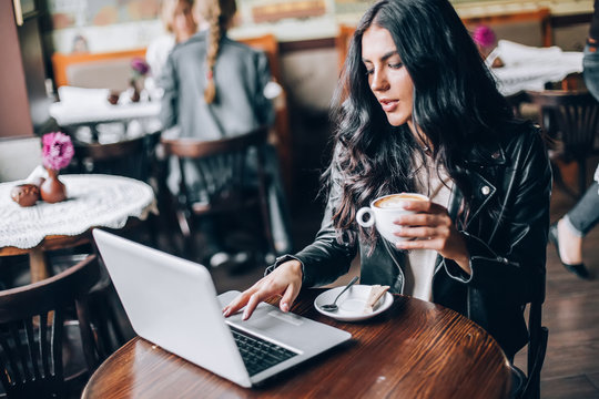 Young Pretty Spanish Woman In Cafe In City Centre With Tablet Laptop