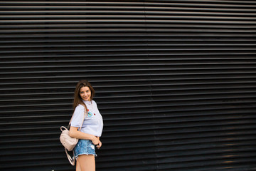Obraz premium Young happy woman jump near city building wall