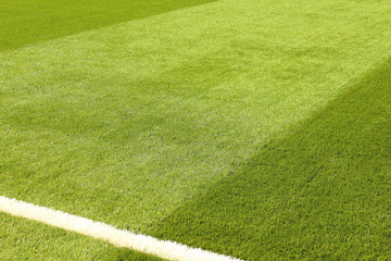 Artificial synthetic lawn on a football field. Close-up. Background. Texture.