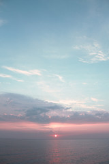 A beautiful sunrise on the horizon above the sea. Cloudy sky and calm sea. Photo of an amazing nature