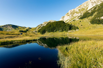 Naklejka na ściany i meble Beautiful mountain reflection on lake.Crystal clear reflection of mountains in the lake