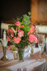 Wedding Reception Table Decorated with Silver and a Pink, White, and Green Centerpiece of Roses