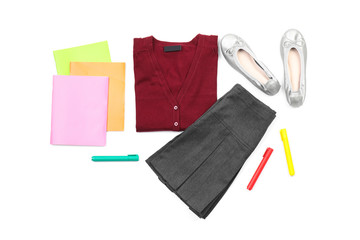 Stylish school uniform and stationery on white background, top view