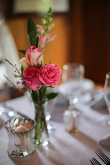 Wedding Reception Table Decorated with Silver and a Pink, White, and Green Centerpiece of Roses