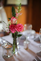 Wedding Reception Table Decorated with Silver and a Pink, White, and Green Centerpiece of Roses