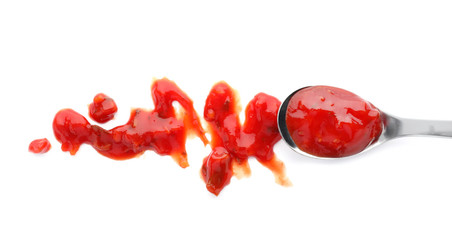 Spoon with spicy chili sauce on white background, top view