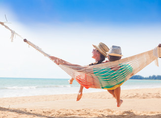 Young couple in love relaxing in a hammock by the beach © el.rudakova