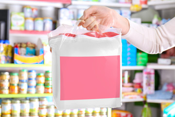 Woman holding package with diapers for baby in store