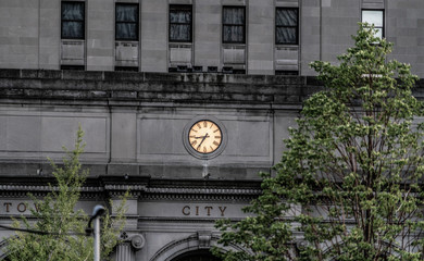 Tower clock fixated on century old building in public square in downtown Cleveland, Ohio