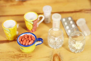 Pack of pills ready to take, on the wooden table.  All kind of pills.