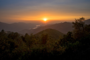 Obraz premium Setting Sun and Sunburst Over Sierra Foothills - Taken From Yosemite Highway 120