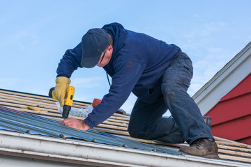 Man working on tin roof