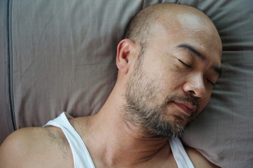 Obraz premium portrait of bald beard Japanese sleeping man on grey pillow