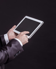 experienced businessman with digital tablet on black background.