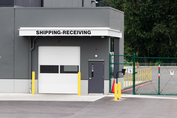 Warehouse building shipping receiving garage door and gate with road driveway