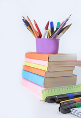 books and a variety of office supplies on white background .phot