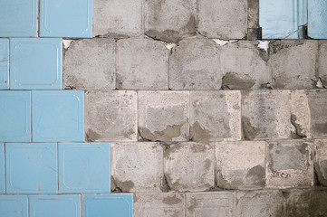 Concrete old wall with the remains of tiles and tile mortar. Background, texture.