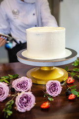 The chef's confectioner cooks a cake and decorates it with fresh flowers. background image.