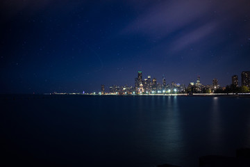 A evening skyline view of Chicago with star trails and moving clouds