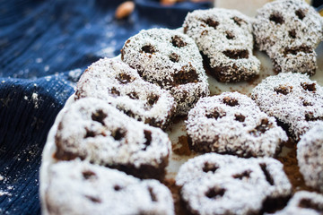 Sweet skull shaped vegan sweets - coconut, cocoa, dates and walnuts - for halloween party or kids healthy breakfast. Raw vegan vegetarian food.