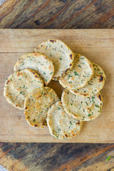 Naan chapati bread with garlic, fresh greens and herbs fried on dry pan. Traditional Asian Indian whole wheat flour flat bread. Raw vegan vegetarian food