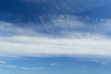 Naklejka na ściany i meble Spindrift clouds in deep blue sky