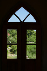 Arched window looking out to green landscape