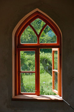 Arched window looking out to green landscape