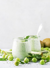 Smoothies from gooseberry, kiwi and yogurt with chia seeds, gray background, selective focus