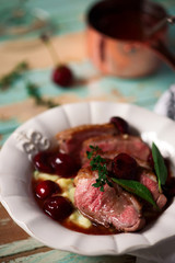 Duck breast with cherry sauce and polenta.style rustic