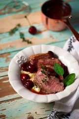 Duck breast with cherry sauce and polenta.style rustic