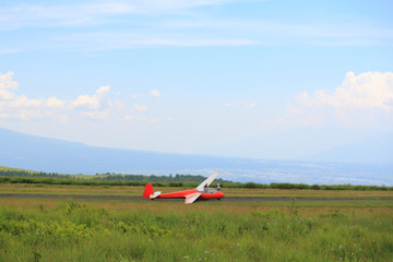 Fototapeta na wymiar 草原に転がる赤いグライダー