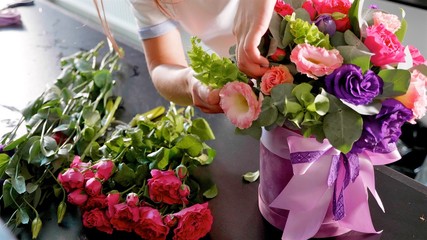 Florist girl makes a floral box in a flower salon, close-up