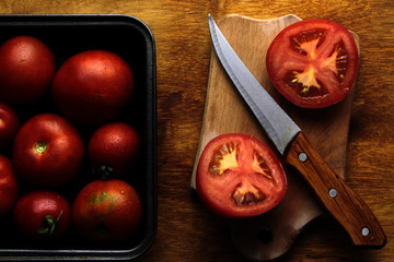 tomatoes and knife on cutting board background