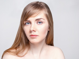 Pretty caucasian woman with long hair poses in studio, close up portrait