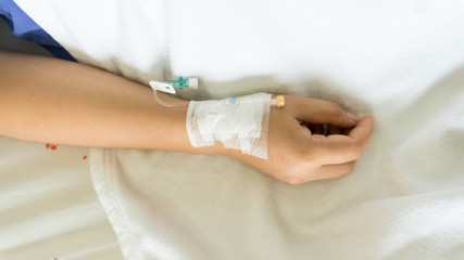 patients on the bed have injecition saline show hand and arm