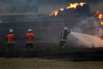 Obraz premium Feuerwehrmänner löschen einen Feldbrand