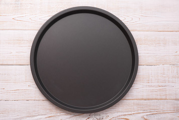 Empty baking tray for pizza close up on wooden background top view horizontally. Mock up for design