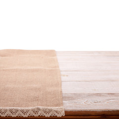 Canvas napkin with lace, tablecloth on wooden table on white background. Can used for display or montage your products. Selective fokus.