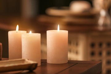 Fototapeta na wymiar Burning candles on table in spa salon
