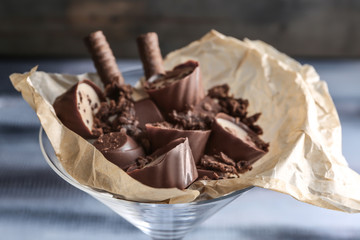 Glass with delicious chocolate candies, closeup