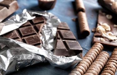 Delicious chocolate with rolled wafer cookies on wooden table