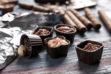 Delicious chocolate candies on wooden table