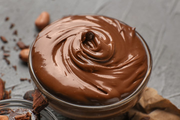 Glass bowl with molten chocolate on table, closeup