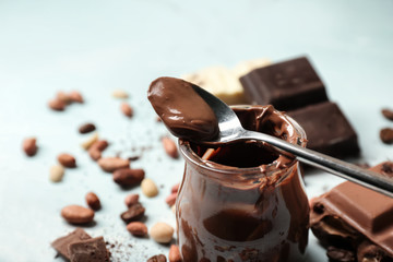 Jar with molten chocolate on table