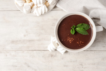 Cup of hot chocolate with marshmallows on wooden table