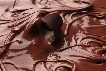 Piece of curl in tasty melted chocolate, closeup
